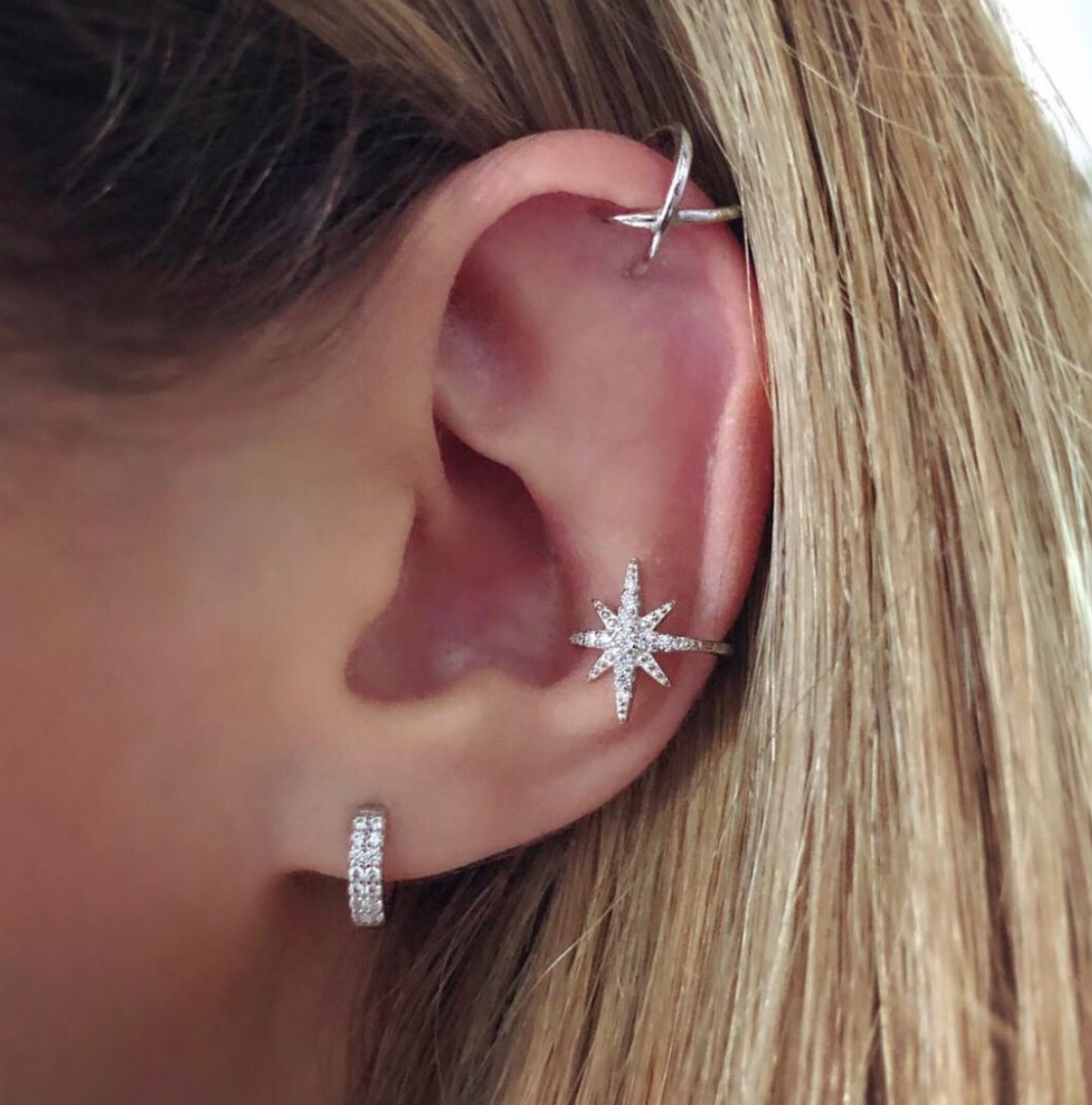 Cubic zirconia encrusted huggie hoops with multiple Riptide 5 earrings including silver starburst ear cuff, and sterling silver criss cross ear cuff